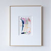 Framed abstract artwork with colorful brush strokes on a white wall