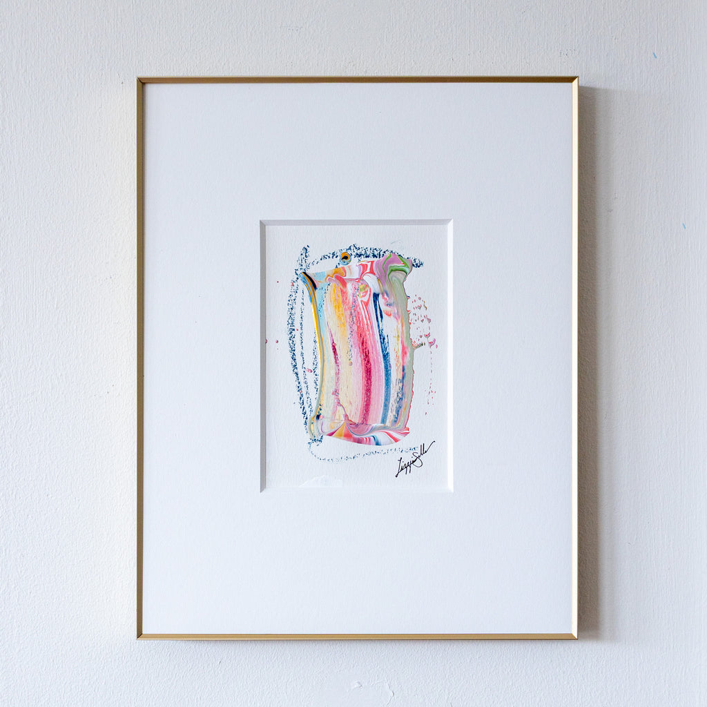Framed abstract artwork with colorful design on a white wall