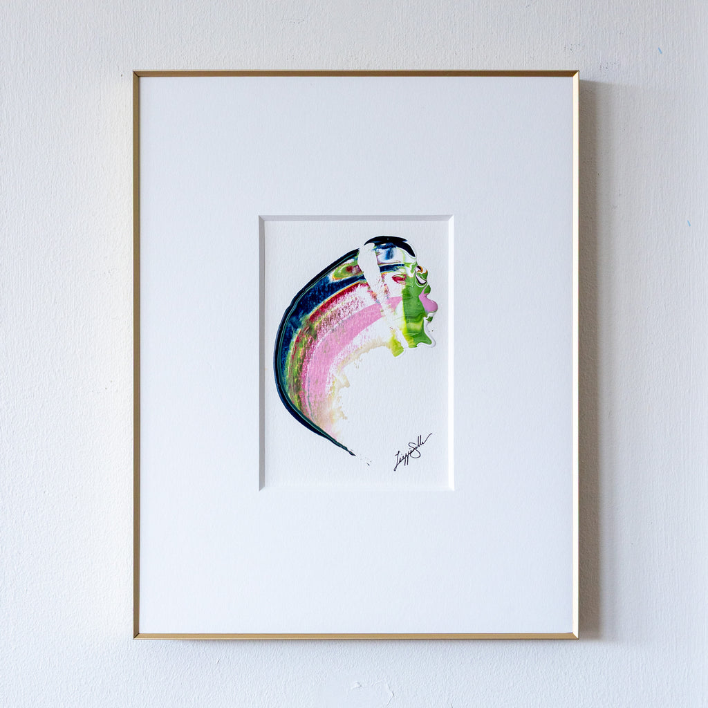 Framed abstract artwork with curved shape in gold frame on white wall