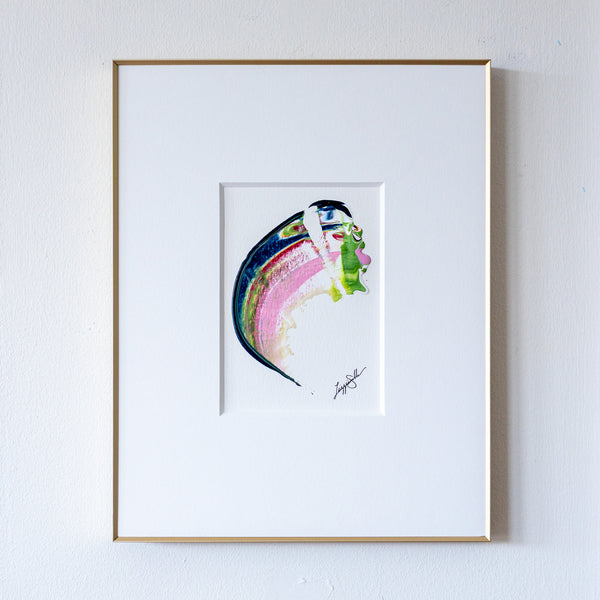 Framed abstract artwork with curved shape in gold frame on white wall