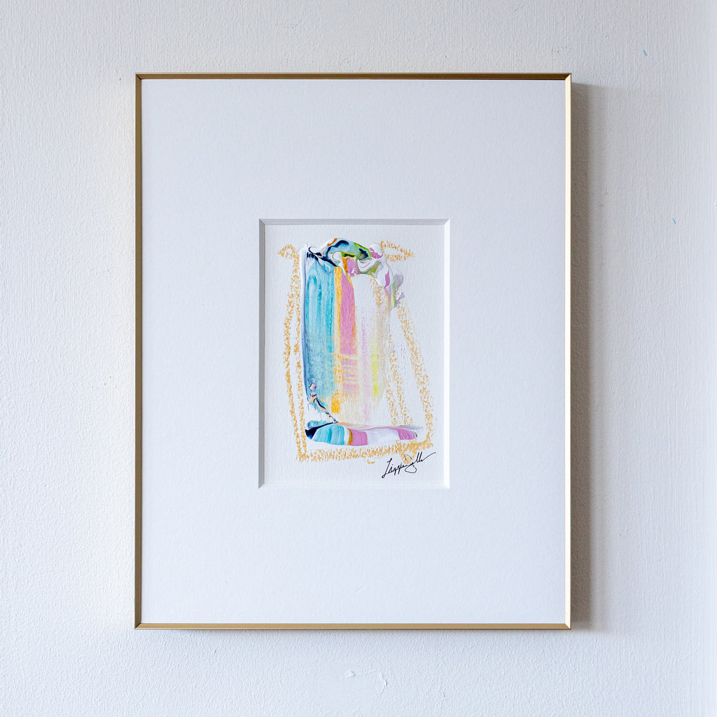 Framed abstract artwork with colorful design on a white wall
