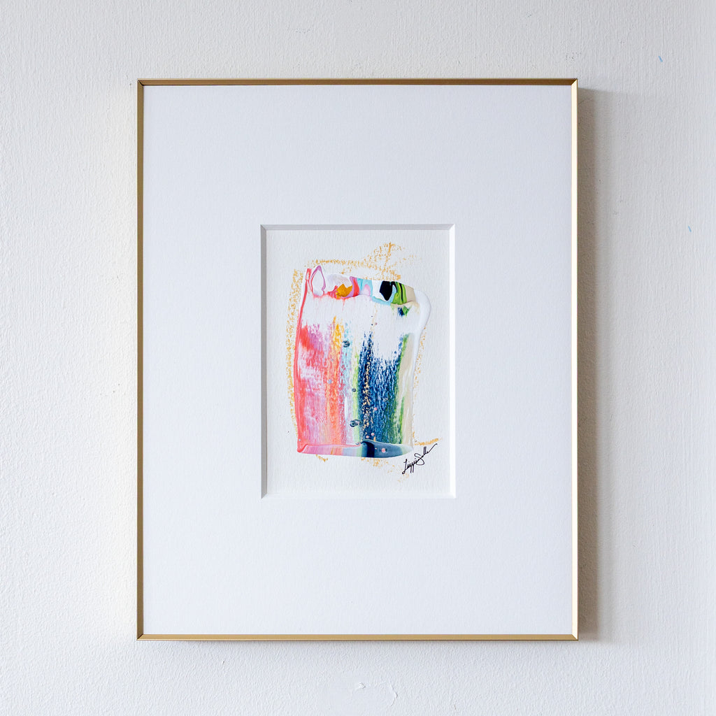 Framed abstract painting with colorful design on a white wall