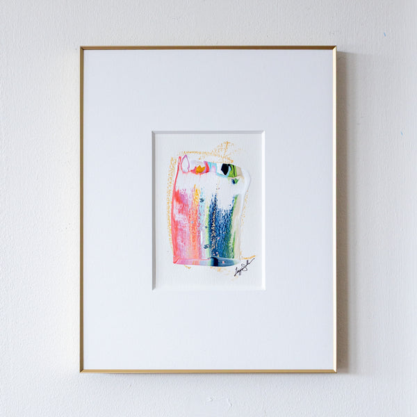 Framed abstract painting with colorful design on a white wall