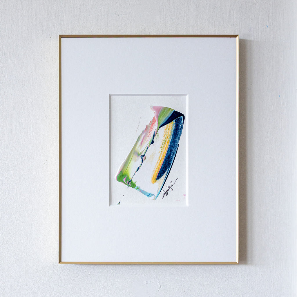 Framed abstract painting of a colorful abstract design on a white wall