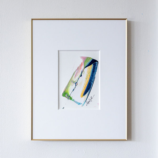 Framed abstract painting of a colorful abstract design on a white wall