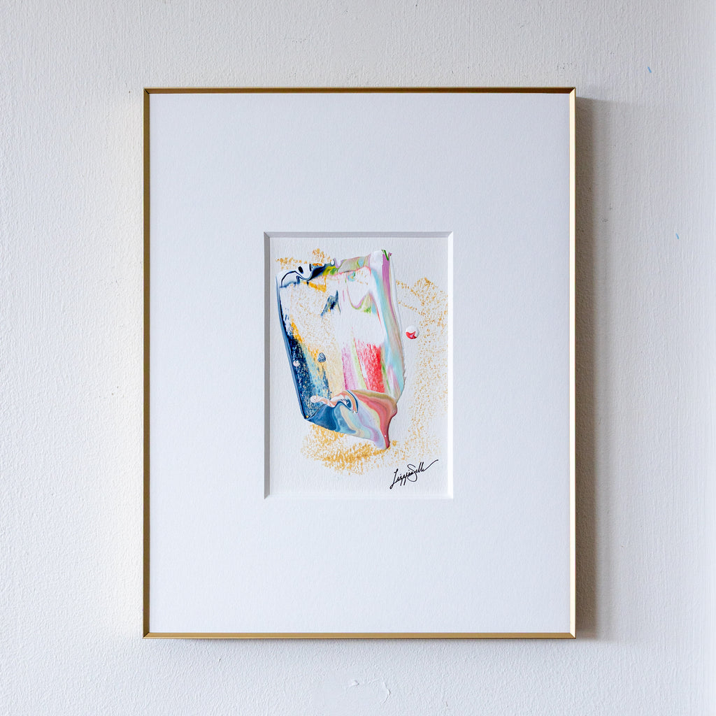 Framed abstract painting on a white wall