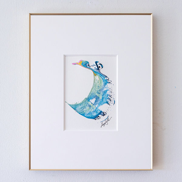 A framed abstract artwork, set in a white mat and a thin gold frame against a white wall.
