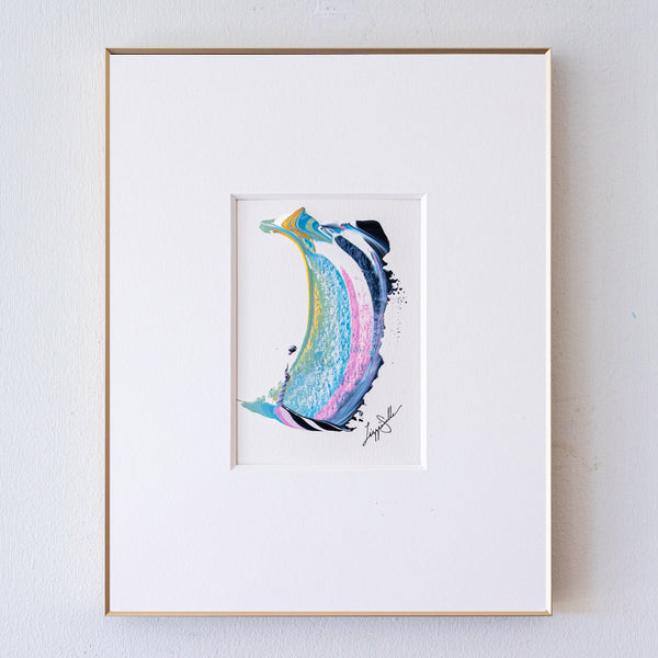 A framed abstract painting, displayed in a white mat with a thin gold frame against a light gray wall.