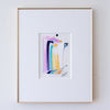 A framed abstract artwork, set within a white mat and a thin gold frame on a light gray wall.