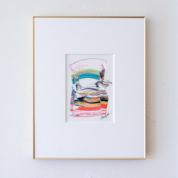 A framed abstract artwork featuring colorful horizontal brushstrokes, presented in a white mat and a thin gold frame against a white wall.