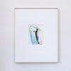 A framed abstract painting featuring a vertical swish in shades of blue, white, and yellow, presented in a white mat and a thin gold frame against a light gray wall.