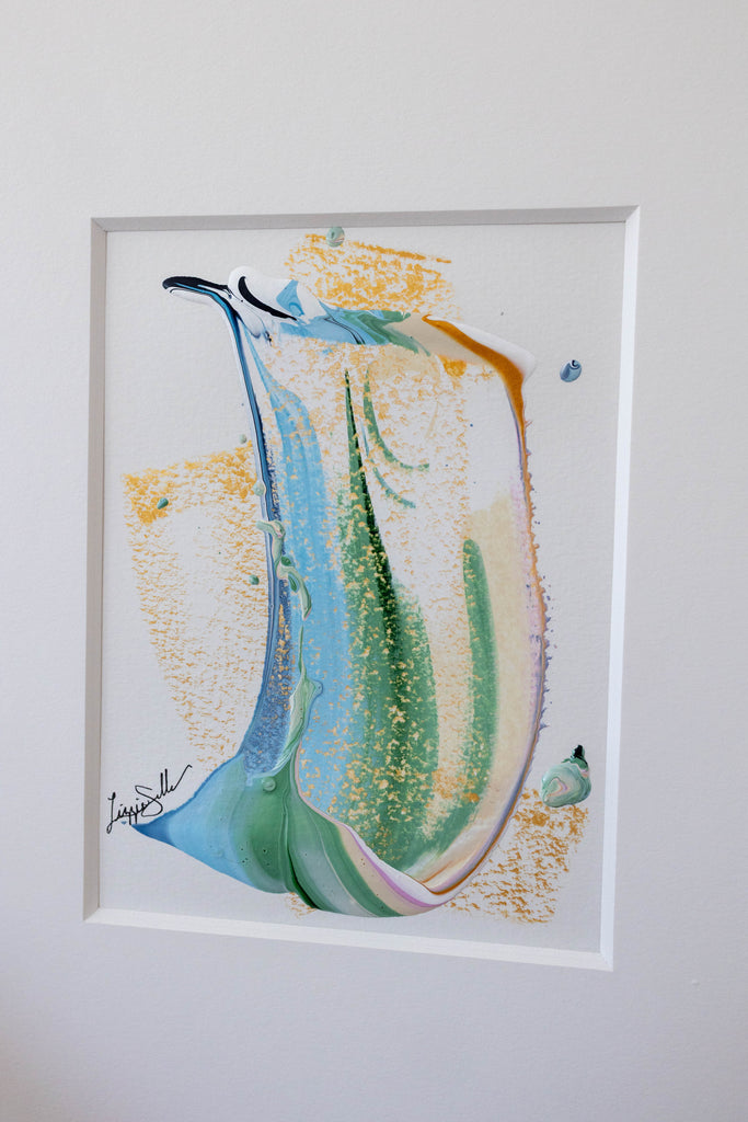 A framed abstract painting featuring an abstract swish with blue, green, and gold brushstrokes on a white background.