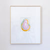 A framed painting featuring a colorful abstract agate slice in pink, gold, and green, set within a white mat and a thin gold frame, mounted on a white wall.