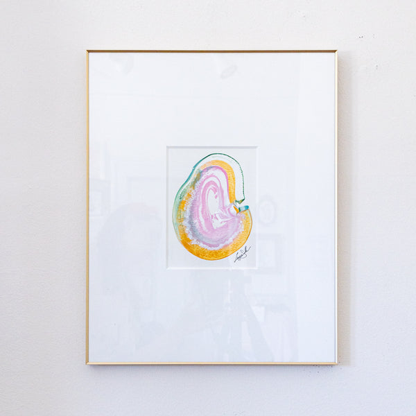 A framed painting featuring a colorful abstract agate slice in pink, gold, and green, set within a white mat and a thin gold frame, mounted on a white wall.