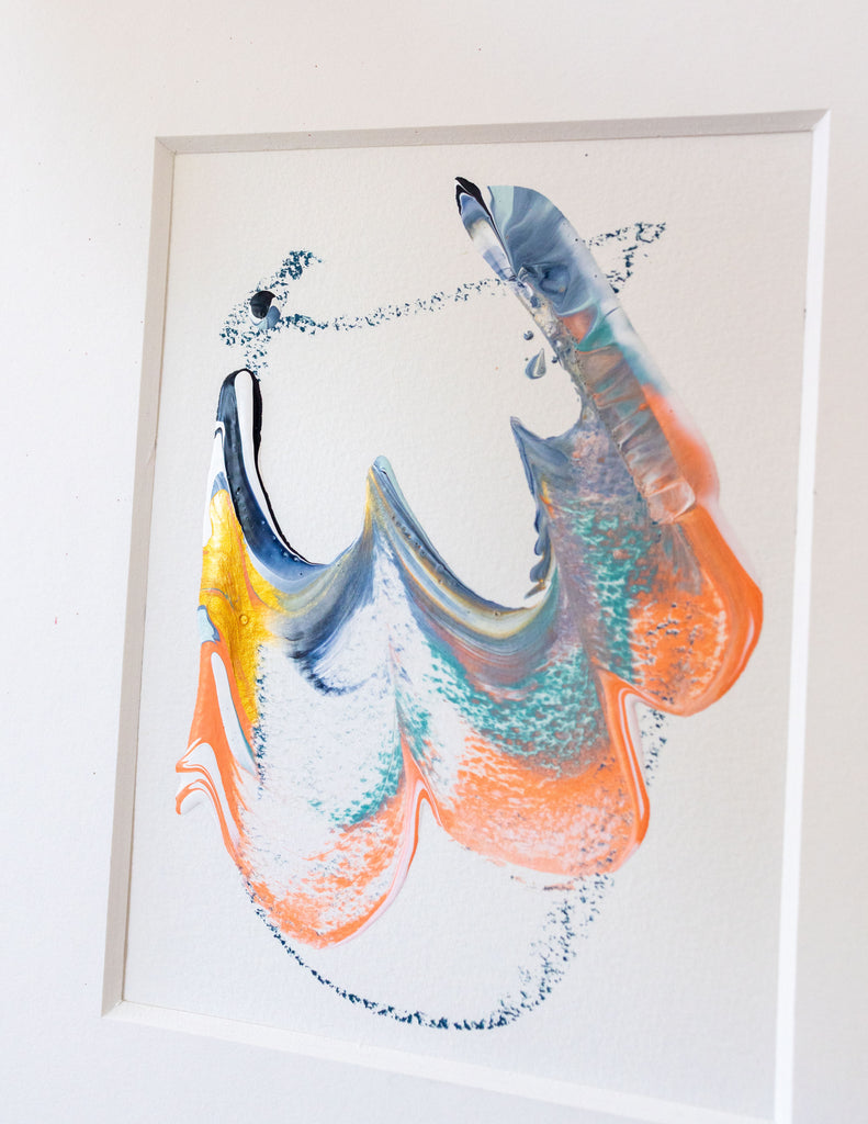 A framed abstract painting featuring blue, coral, blue, gold, and black in a white mat.