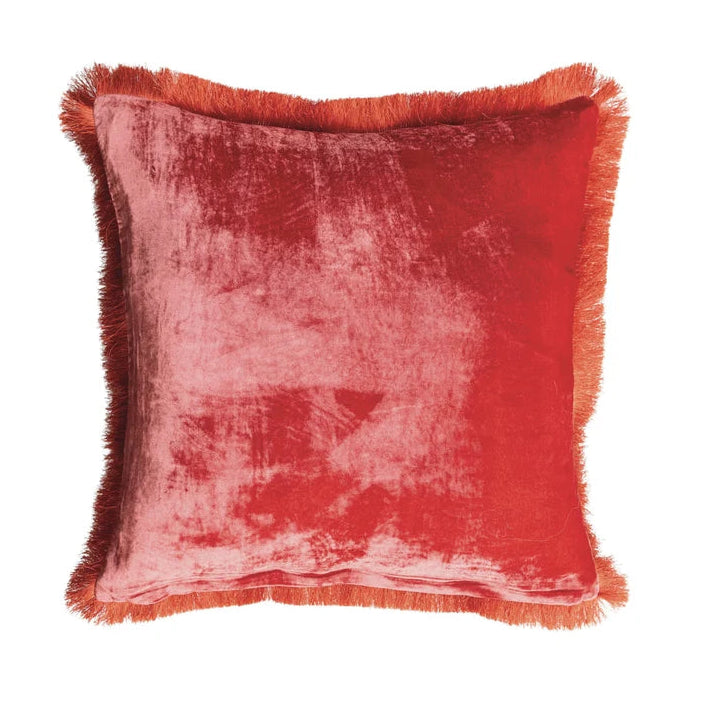 A square red velvet throw pillow with fringed edges, shown against a plain white background.