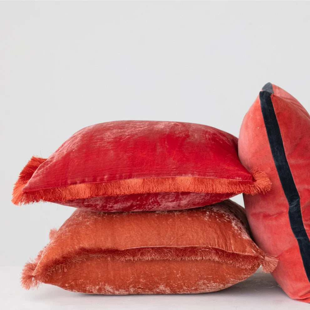 Stack of red textured pillows on a light gray background