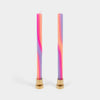 Two colorful candles with gold holders on a light gray background