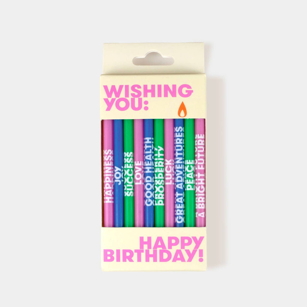 A boxed set of colorful birthday candles with motivational phrases, shown in its retail packaging against a light gray background.