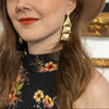 Woman wearing a floral dress and beige hat in an art gallery setting