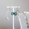 Glass ball Earrings on a white stand with a neutral background