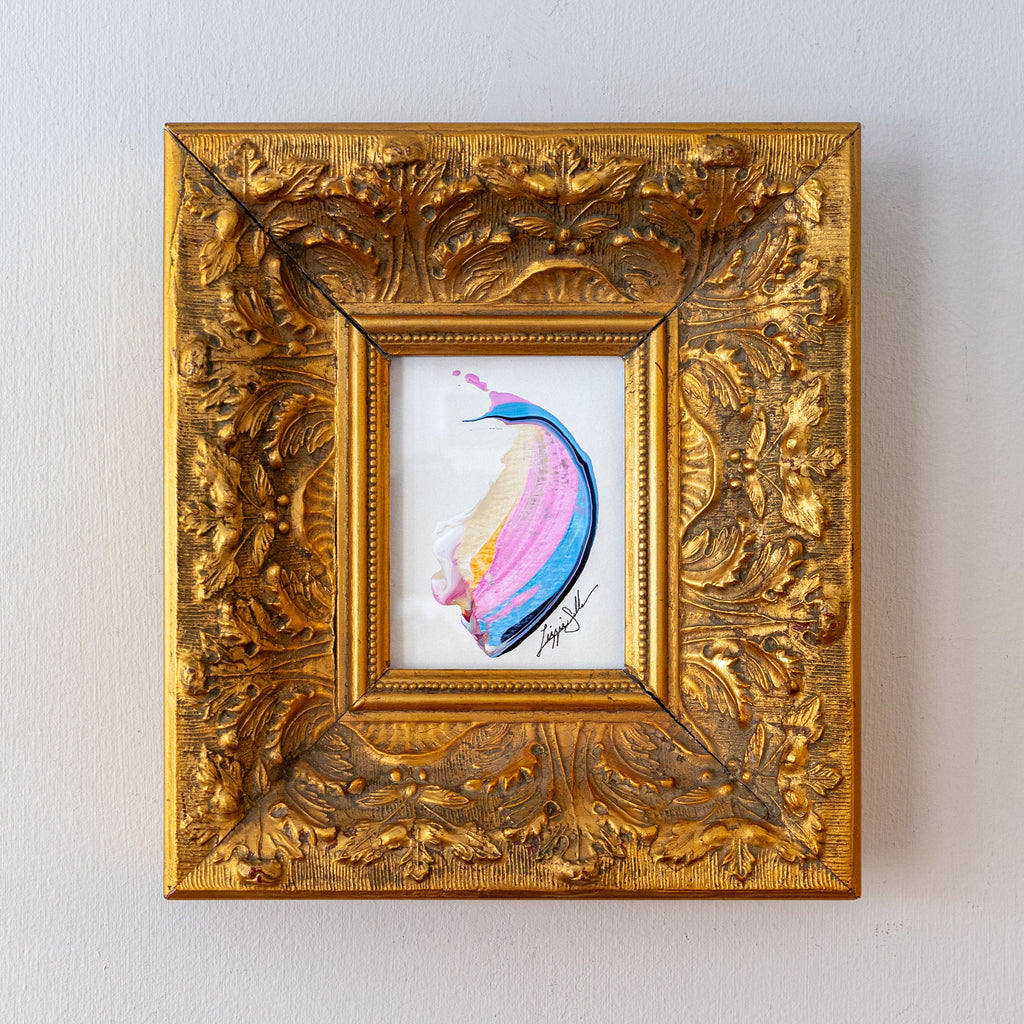 Decorative gold frame with a colorful abstract painting inside on a light gray background