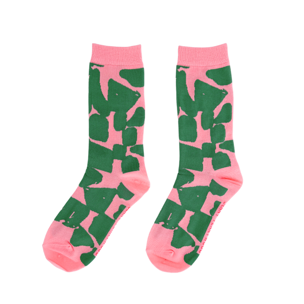 Pink socks with green abstract pattern on a white background