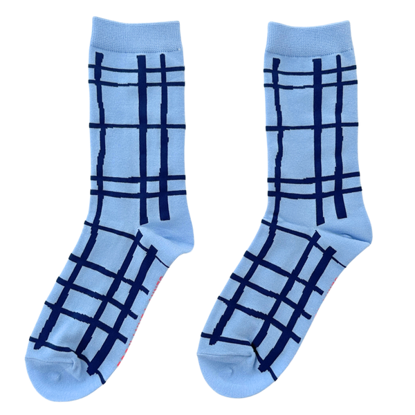 Pair of light blue socks with dark blue plaid pattern on a white background