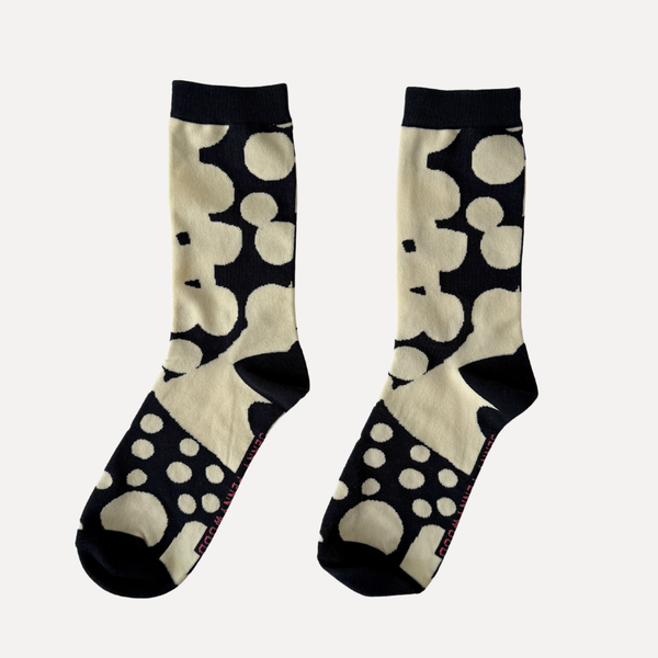 Pair of socks with black and white abstract pattern on a gradient background