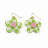 A pair of flower-shaped drop earrings with a green and white checkered pattern, a pink circular center, and gold-tone fishhook wires, shown on a plain white background.