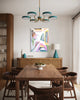 Dining room with wooden table and chairs, colorful abstract painting on the wall, and modern chandelier.