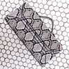 A black and white snakeskin-patterned clutch bag with a matching strap, resting on a white background with a black hexagonal grid pattern.