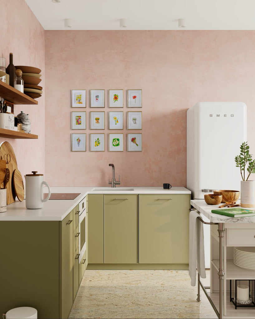Modern kitchen with green cabinets, white appliances, and a pink wall with botanical artwork gallery wall.