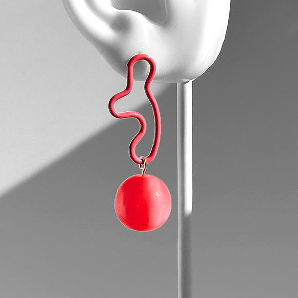 Red earring hanging from a white ear model against a gray background