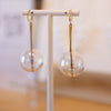 Blown Glass and Gold Earring against blurred background