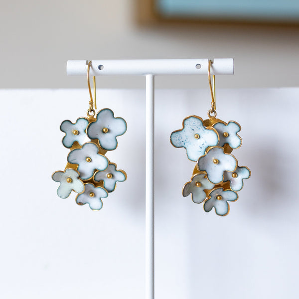 Floral earrings on a white stand with a light background