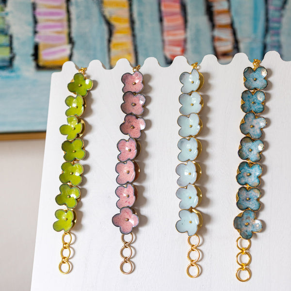 Set of floral beaded earrings on a white card with a colorful abstract background.