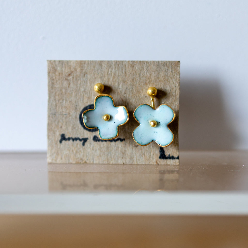 Flower-shaped earrings on a branded card with a light background