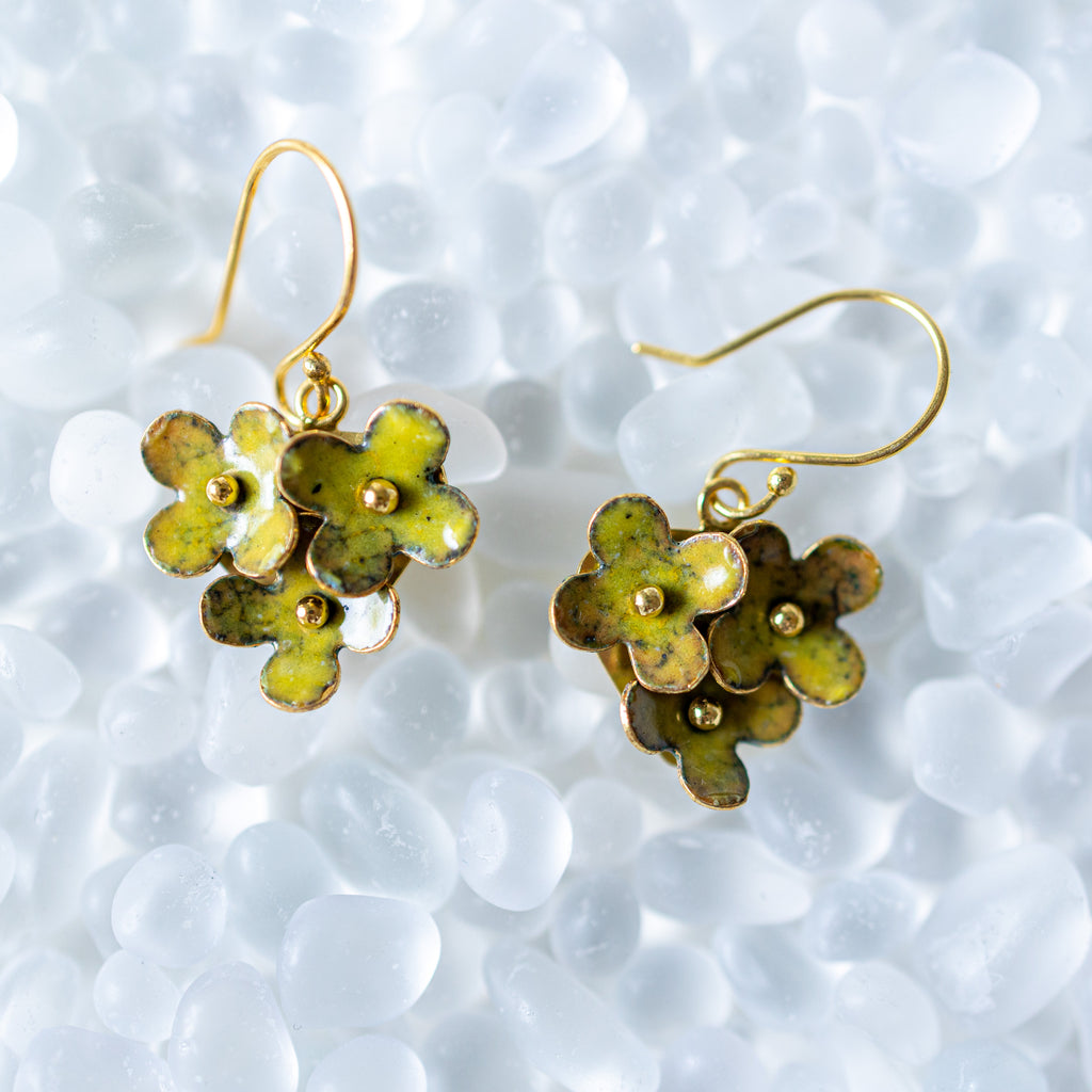 Floral earrings with gold accents on a textured white background