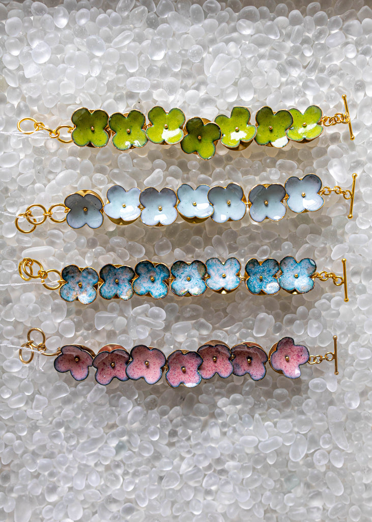 Set of three floral-patterned bracelets on a textured surface
