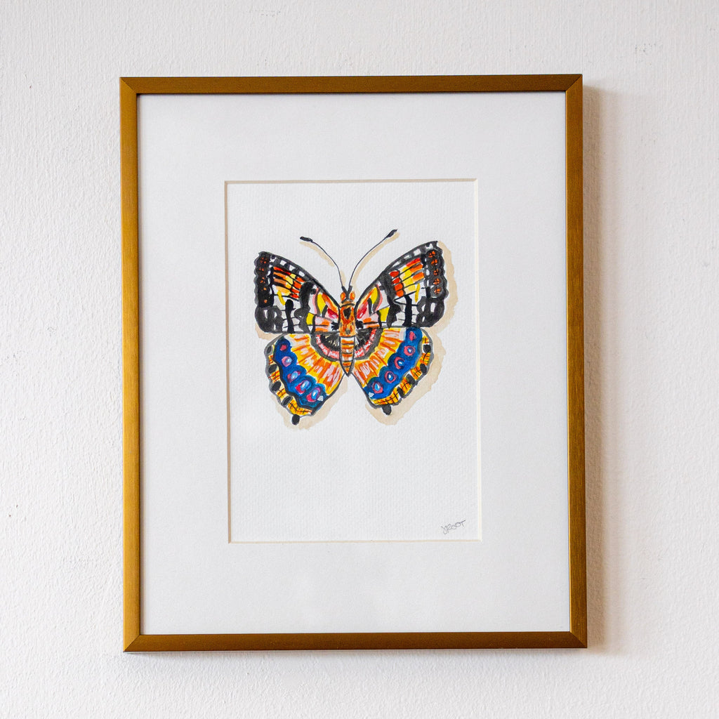 Framed artwork of a colorful butterfly on a white wall