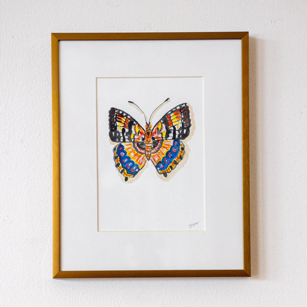 Framed artwork of a colorful butterfly on a white wall