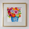 Framed artwork of a colorful floral arrangement on a white wall