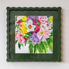 Framed painting of colorful flowers on a white wall