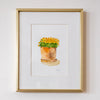 Framed artwork of a potted plant on a white wall
