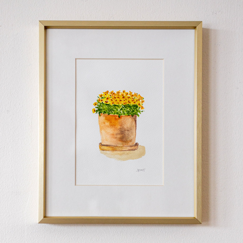 Framed artwork of a potted plant on a white wall