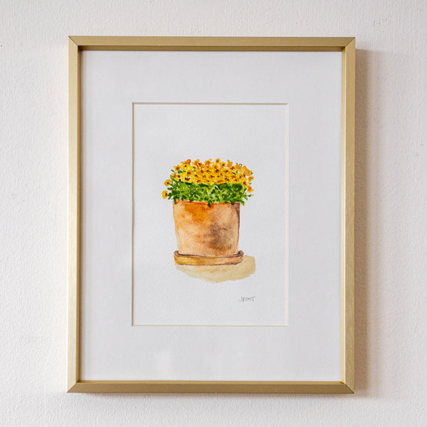 Framed artwork of a potted plant on a white wall
