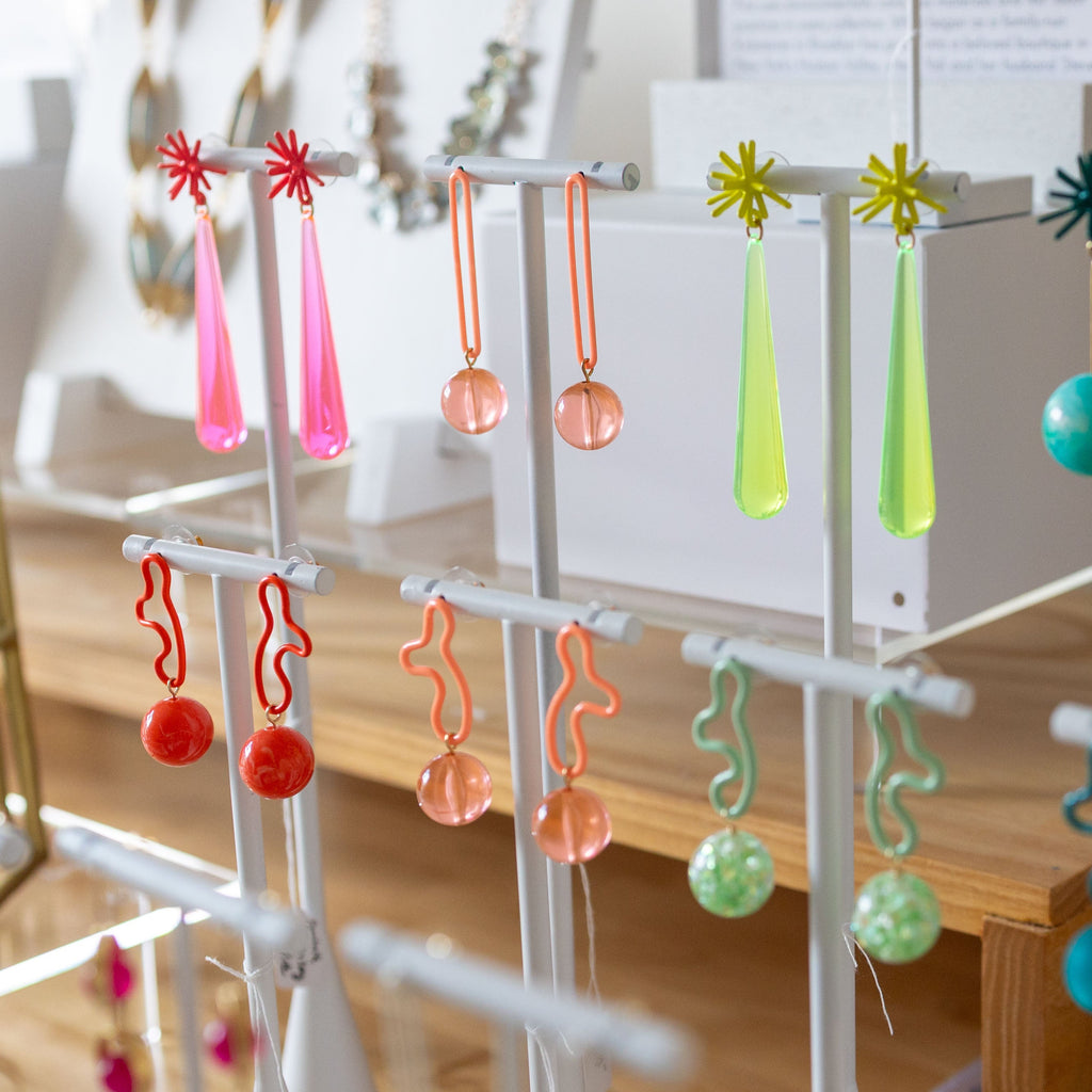 Colorful earrings on display stands in a store setting