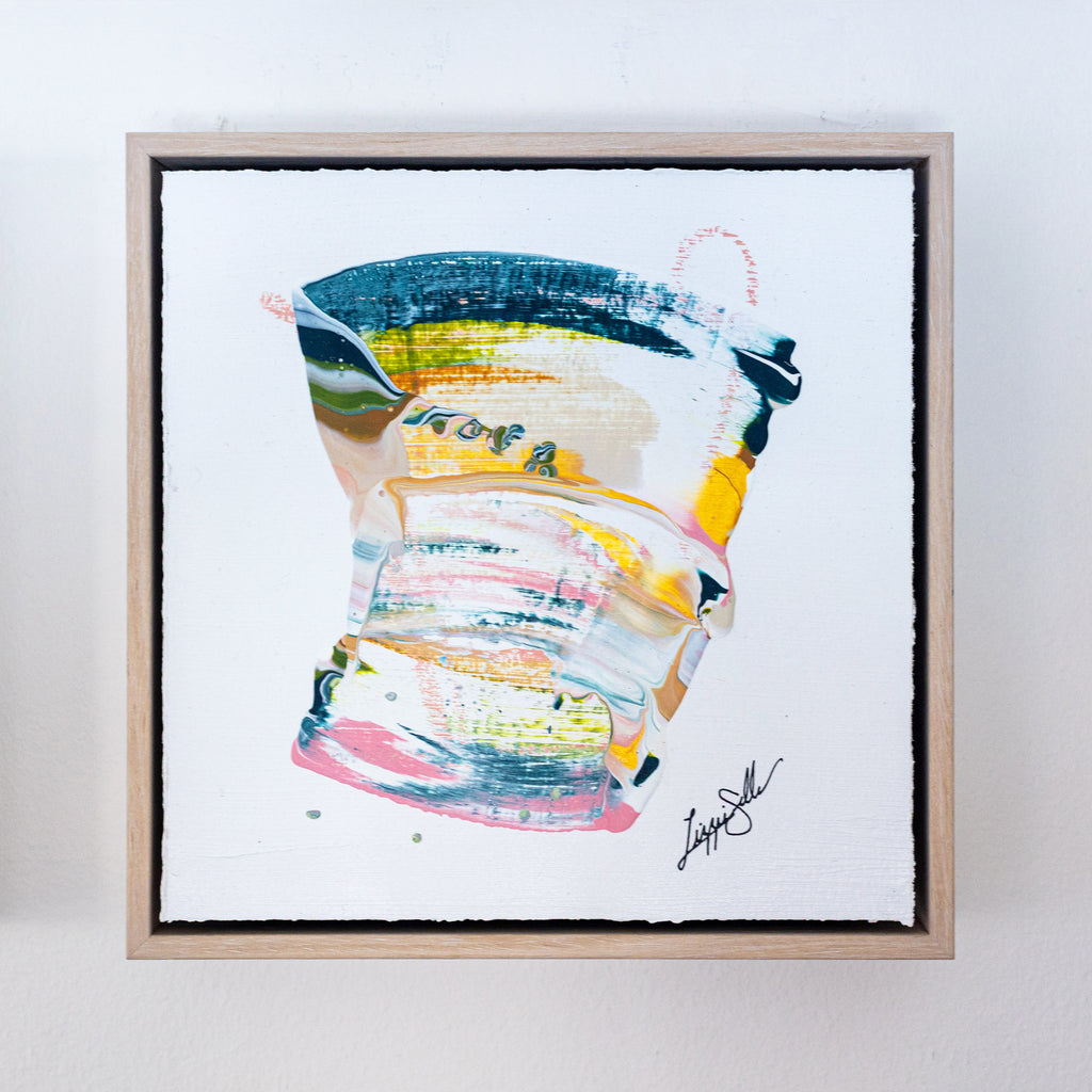 Framed abstract art piece with colorful brush strokes on a white background
