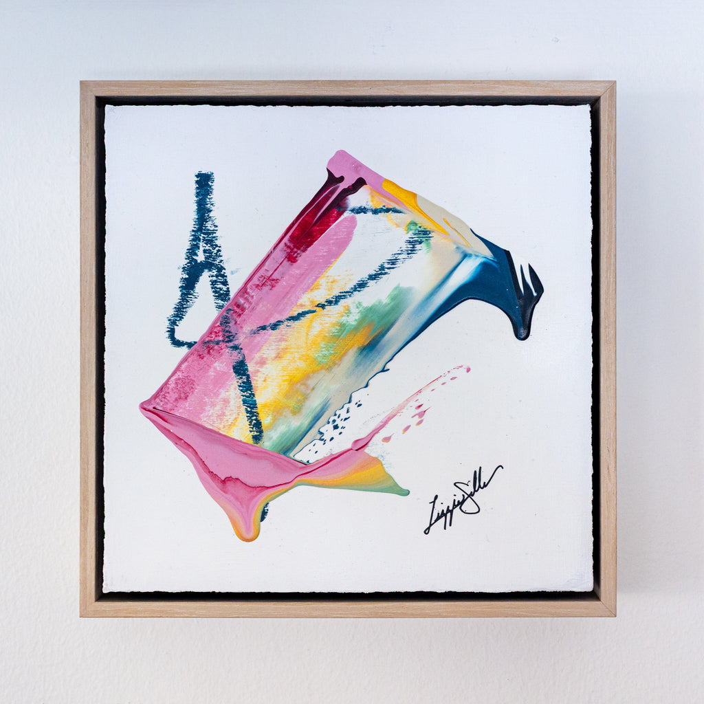 Framed abstract artwork with colorful splashes on a white background